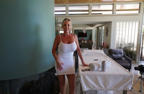Sandra Otterson, femme au foyer sexy, laisse apparaître ses seins dans une courte robe blanche.