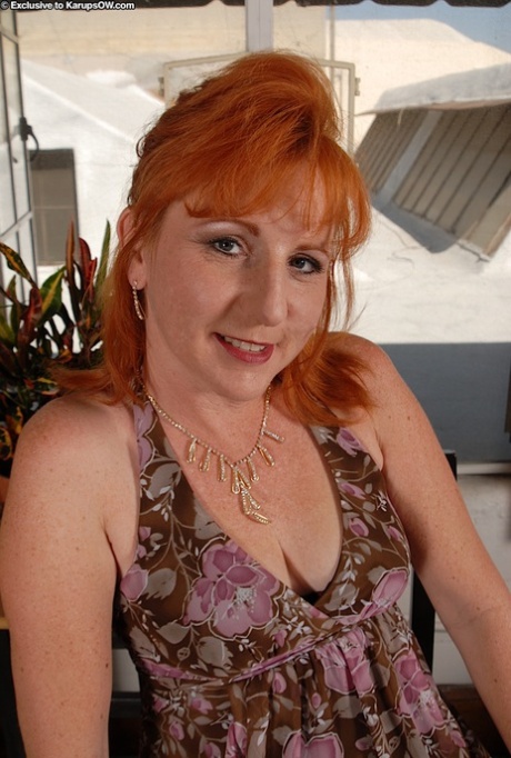 Older redhead removes her dress and pretties to expose the pinkest pussy going