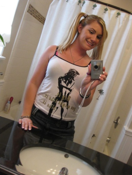 Blonde Hayden Night tager selfies på badeværelset, mens hun slikker på en slikkepind
