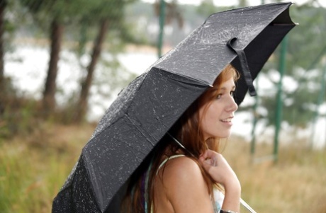 Lekkere tiener Anouk buiten in de regen wrijvend over haar gladde gespreide kutje