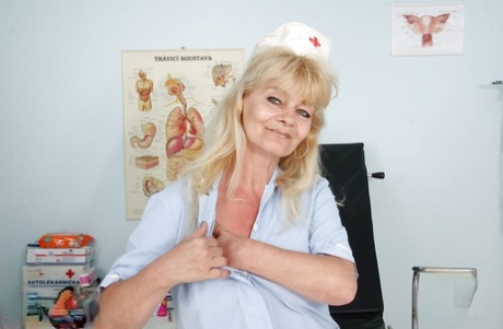 Filthy granny in nurse uniform masturbating her twat with toys