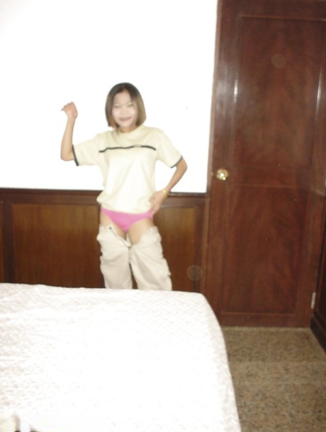 Une séduisante adolescente asiatique aux seins minuscules prenant une douche et posant nue