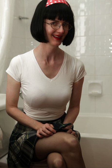 Brudna dojrzała kobieta w okularach mocząca ubrania pod prysznicem