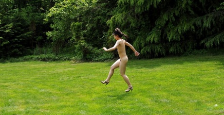 小ぶりなおっぱいと毛深いオマンコの全裸のアジア系美少女が野外で楽しんでいる。
