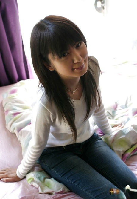 Una ragazza asiatica con il culo pulito che si spoglia di tutti i suoi vestiti