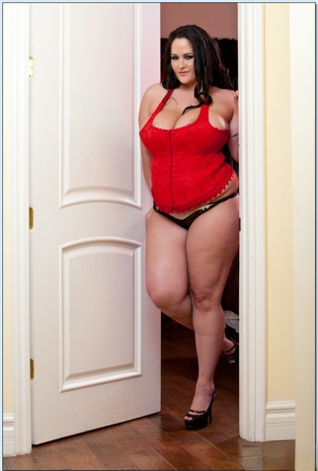 Carmella Bing, femme BBW, se déshabille de son corset rouge et presse ses gros seins