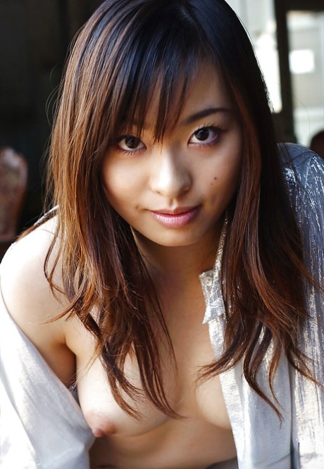 Petite ragazza asiatica Hikaru Koto togliersi la camicia e in posa in topless