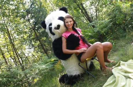 Nezbedná teenagerka se štíhlým tělem se baví s pandí hračkou venku