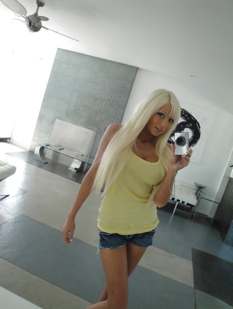 Blond hottie med stora bröst Rikki Six strippar och fotograferar sig själv