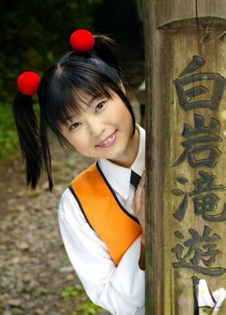 Smilende asiatisk pige afslører sine små bryster og buskede kusse udendørs