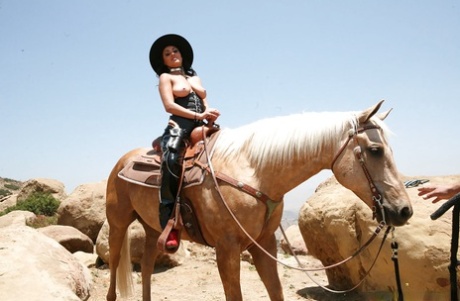 A latina peituda Charley Chase posa ao ar livre com um fato de cowgirl elegante