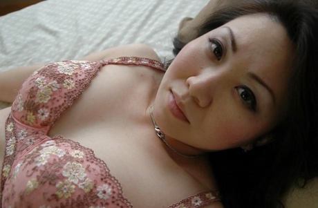 Aziatische MILF ontdoet zich van haar lingerie en laat haar harige kut zien
