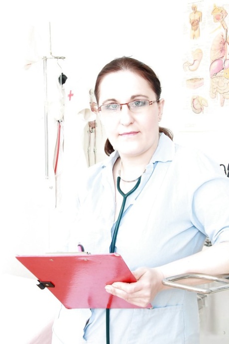 Knubbig sjuksköterska i glasögon som blottar och fingrar sin håriga fitta