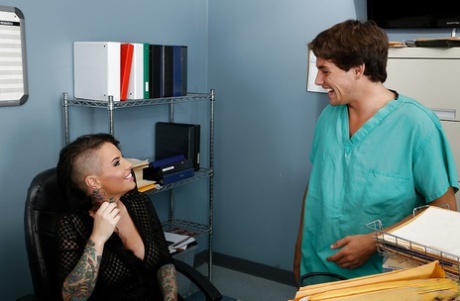 Uma puta de escritório tatuada e incrivelmente quente leva com a sua cona peluda na boca