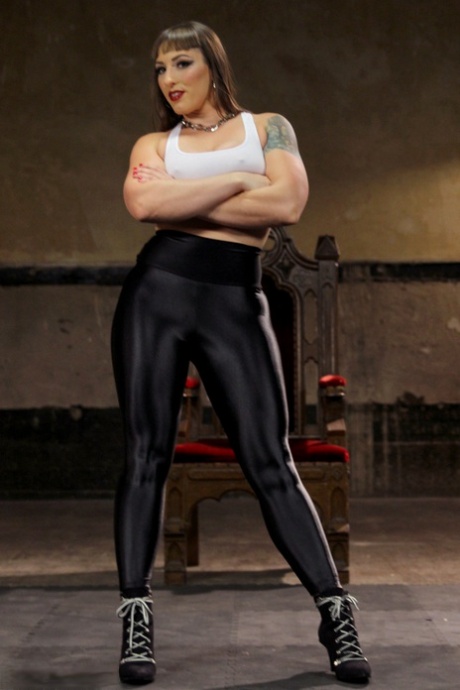 La dominatrice musclée Mistress Kara s'exhibe dans un legging en latex noir.