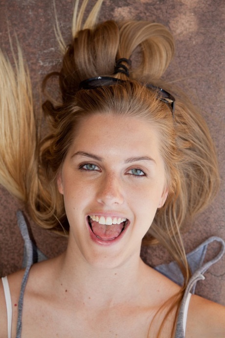 Amateur basketball player Holly Benson poses in tiny jean shorts & bra outside