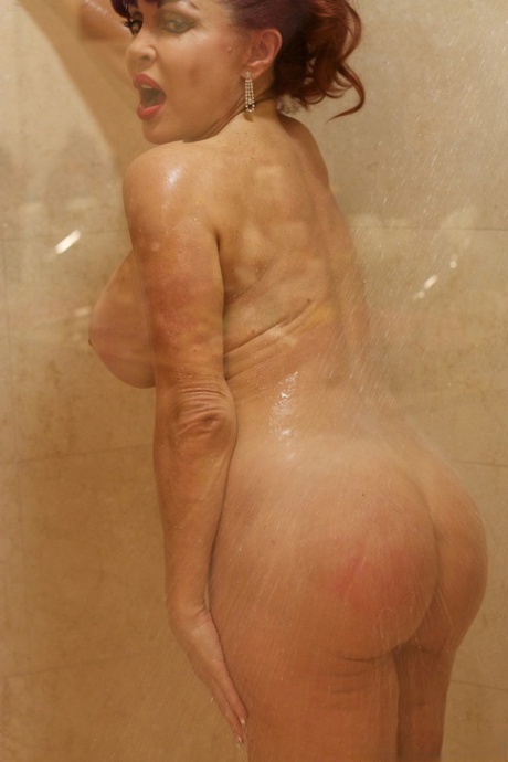 Vanessa, la rousse MILF, exhibe ses gros seins et ses fesses rondes sous la douche.