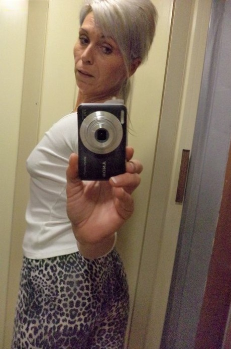 Tjeckiska Kathy White tar selfies i spegeln medan hon strippar