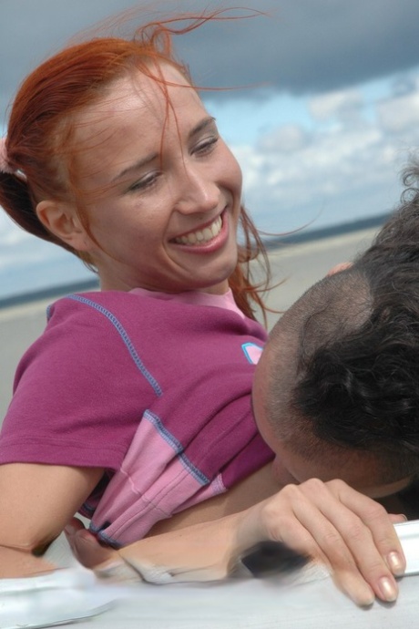 Die rothaarige Teenagerin Kimberly reibt ihre Brustwarzen, während sie auf einem Boot einen warmen Knopf reitet