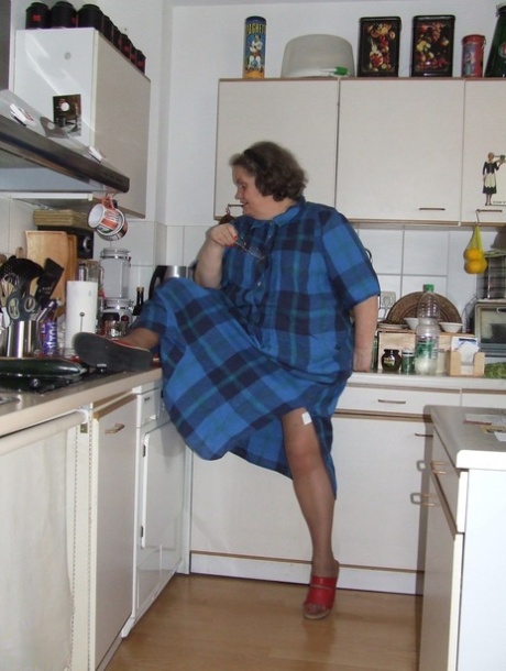 Dikke rijpe huisvrouw Birgid masturbeert met een komkommer in de keuken