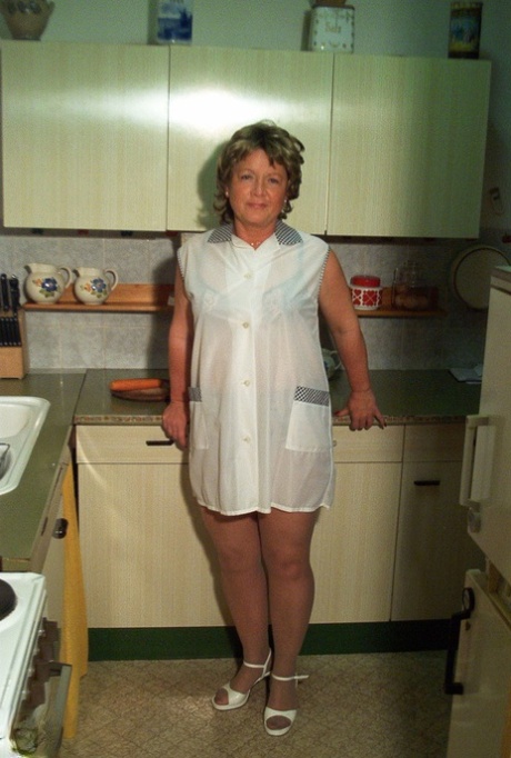 La nonnina minuta Rita si toglie il vestito e le calze di nylon e si masturba in cucina