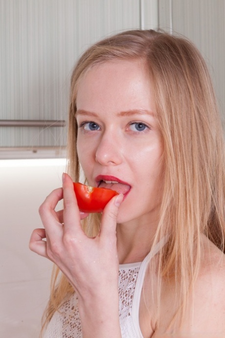 Adorabile teenager con rossetto rosso Alexandra si strofina il pisello cespuglioso in cucina