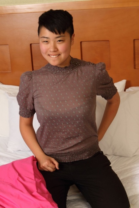 Exotische asiatische Lesbe Melissa schält sich auf dem Bett und enthüllt ihren getrimmten haarigen Biber