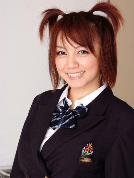 梳着小辫子的日本女学生Meguru Kosaka穿着学生制服摆出姿势