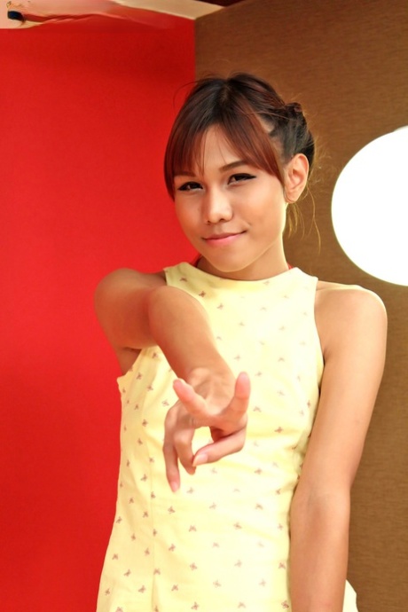 Aziatische ladyboy Nongtoey verwijdert haar gele jurk en poseert met haar lul uit