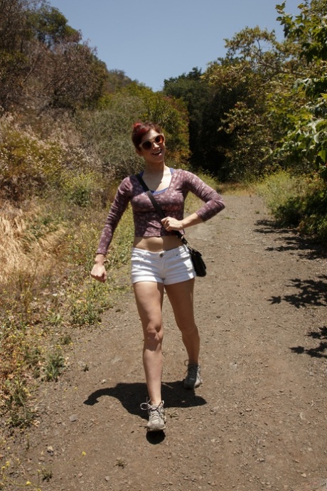 Jazz Reilly, une femme toute en jambes, montre sa souplesse après une randonnée en forêt.