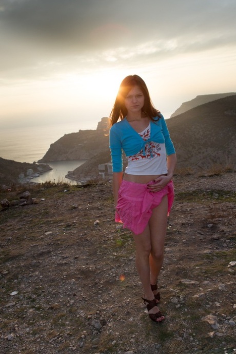 Štíhlá teenagerka s malými prsy Elena May si tře chlupatou štěrbinu na skalách