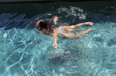Brünette im Bikini Mischa Brooks schwimmt im Pool und nimmt eine Dusche