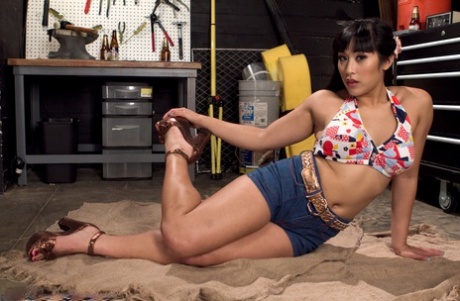 Asiatische Küken Mia Li bekommt auf dem Boden des Ladens und zeigt ihre gespreizten Zehen