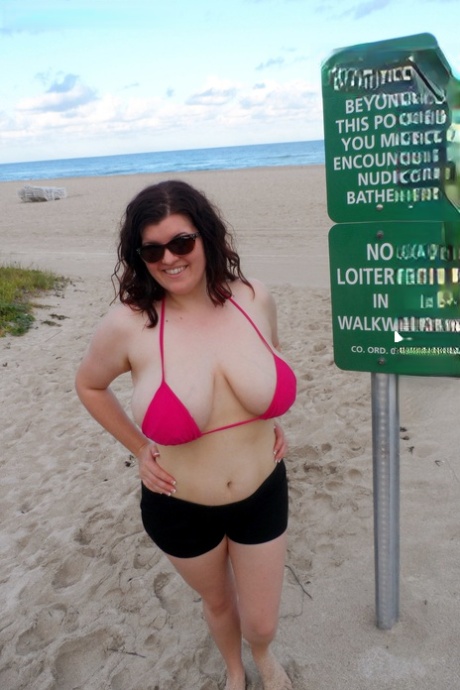 Uma rapariga espessa e solitária desata a trabalhar as suas mamas durante um dia na praia de nudismo.