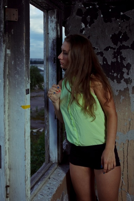 Une fille blanche en chaleur se rend dans un bâtiment abandonné pour se masturber toute seule.