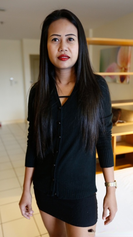 Schlanke Thailänderin zieht ihr kleines schwarzes Kleid für ihre ersten Nacktfotos aus