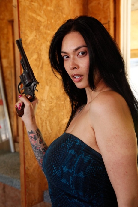 性感的Tera Patrick拿着她的左轮手枪，展示她的大枪和大乳房