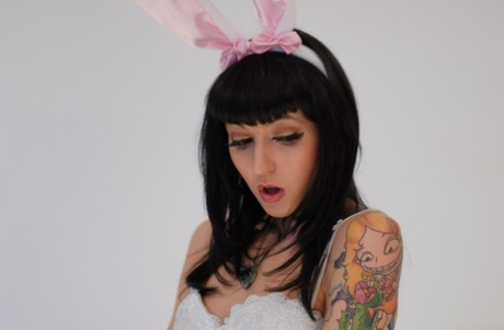 Tatoveret brunette onanerer med en gulerod i en bunny kostume