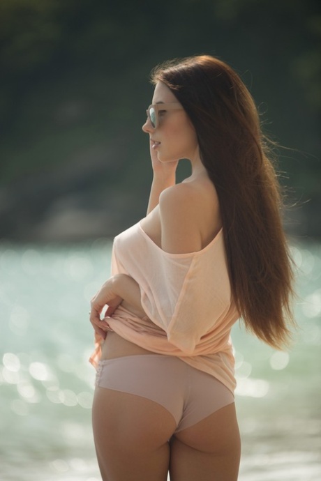 Den barmfagre modellen Niemira viser sine sexy brystvorter mens hun blir våt i havet