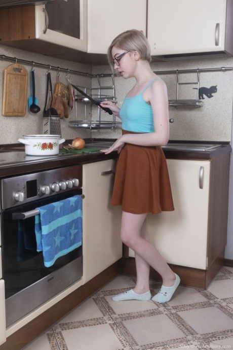 La teenager amatoriale Abby mostra la sua figa pelosa e le sue ascelle in cucina