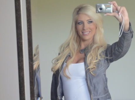 Blonde Tasha Reign smider tøjet og afslører sine bryster, mens hun poserer i spejlet