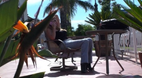 Storbarmet blondine Jezebel Jones i stramme jeans tager imod et telefonsexopkald udendørs