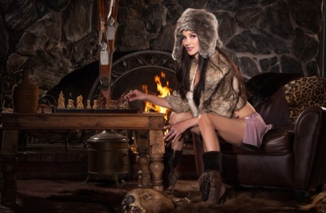 Appealing brunette vixen Erika Knight gets naked showing fake tits by the fire