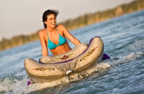 Naturligt bystig Laura Croft i en båt som solar härliga medelstora bröst och kurvig röv