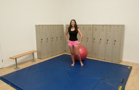 Czech brunette Sandy Ambrosia sits on an exercise ball in the locker room