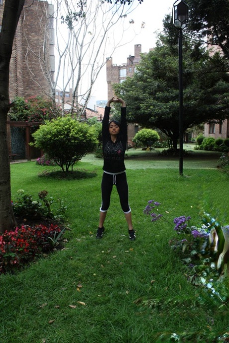 Sportliche kleine Amateurin Maria Jose bearbeitet ihren zierlichen Körper bekleidet im Garten