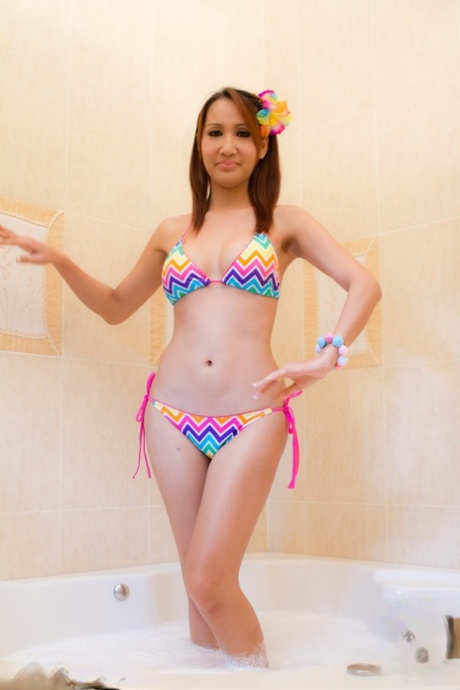 Pretty Ladyboy Nam strips her bikini off in the bathtub and shows nice tits