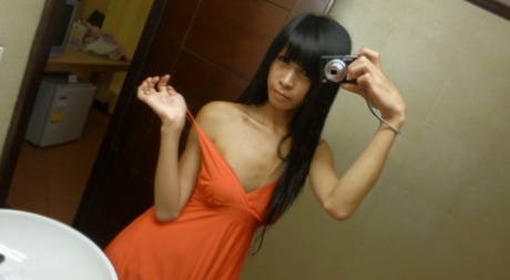 Ladyboys asiáticas delgadas se toman selfies en el espejo mientras se desnudan