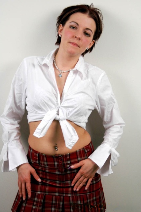 Shy and horny schoolgirl Alicia Avery posing against the wall in short skirt