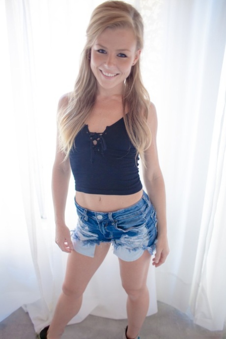 Blonde American girl Nicole Clitman slips jean shorts over her ass and twat